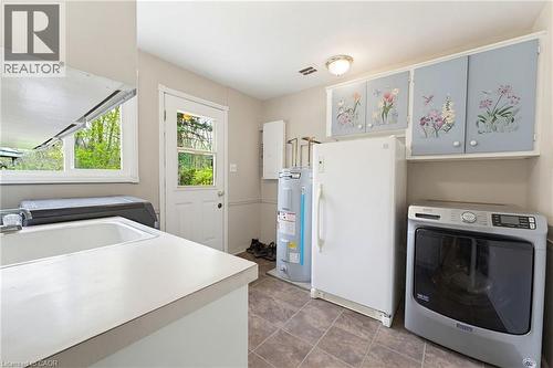 Utility room with a white drop-in sink, durable countertop space, and tiled flooring - 10 Huisman Lane, Hamilton, ON 