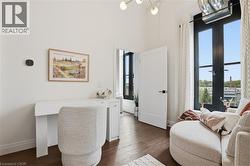 Hardwood-finish flooring throughout, complemented by a modern brass light fixture and large black-framed windows - 