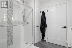 Shower enclosure with a glass door, white subway tile surround, and a decorative mosaic tile accent - 