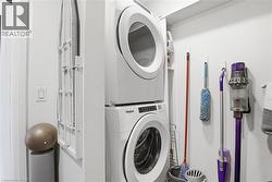 Dedicated laundry area featuring stacked washer and dryer units - 