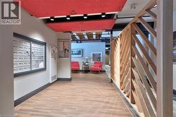 Lobby area featuring wood-finish flooring, a decorative wood partition, recessed lighting, and a mail center - 