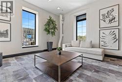 Spacious interior featuring large windows with dark trim, light-colored walls, patterned flooring, and recessed ceiling lighting - 