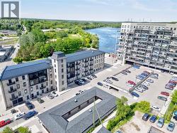 Modern multi-story building featuring extensive windows, a flat roofline, multiple balconies, and an integrated parking structure - 