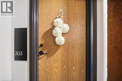 Wood-finish door with a black frame and matte black hardware, featuring a modern unit number plate - 