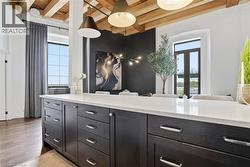 Kitchen island featuring dark wood cabinetry, brushed nickel hardware, and a light-toned countertop - 