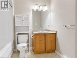 Bathroom featuring a full vanity with wood-finish cabinetry, a built-in sink, and a framed mirror - 