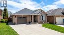 Brick exterior residence featuring a front-facing garage with an arched window, a prominent arched window on the facade, and a covered entry porch - 47 Hannah Crescent, Hamilton, ON  - Outdoor With Facade 