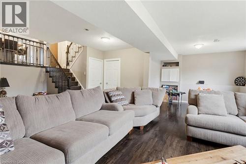 Finished basement space featuring dark wood-finish flooring, recessed lighting, and light-toned wall paint - 47 Hannah Crescent, Hamilton, ON - Indoor Photo Showing Living Room