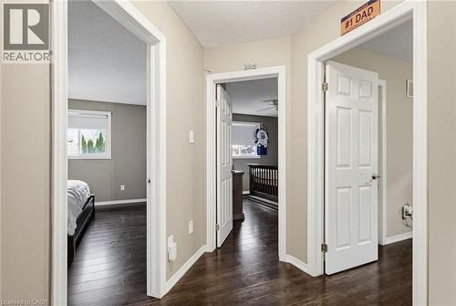 Hallway featuring dark wood-finish flooring, light neutral wall paint, and white trim - 47 Hannah Crescent, Hamilton, ON - Indoor Photo Showing Other Room