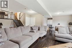 Finished basement space featuring dark wood-finish flooring, recessed lighting, and light-toned wall paint - 