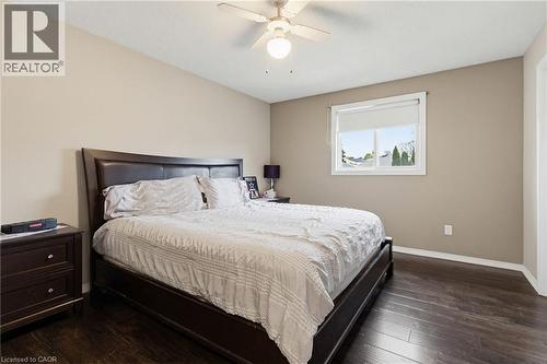 Bedroom featuring wood-finish flooring, a white trim window, a ceiling fan with integrated lighting, and neutral wall tones - 47 Hannah Crescent, Hamilton, ON - Indoor Photo Showing Bedroom