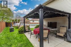 Paved patio featuring a black metal gazebo with string lighting - 