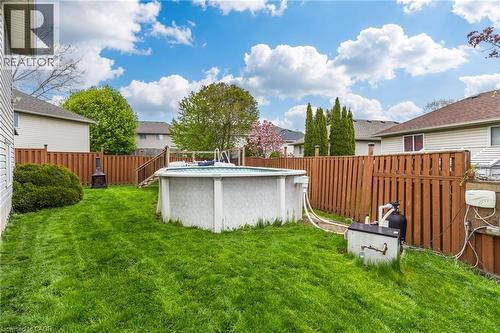 Expansive backyard featuring an above-ground pool with a surrounding wood deck, a wood privacy fence, and a decorative outdoor fire pit - 47 Hannah Crescent, Hamilton, ON - Outdoor With Above Ground Pool
