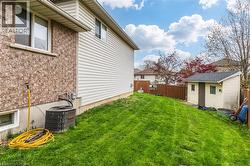 Expansive green space featuring a detached storage shed, privacy fencing, and brick exterior with siding accents - 