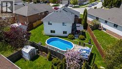 Expansive backyard featuring a large above-ground pool, a spacious wood deck, and a dedicated storage shed - 