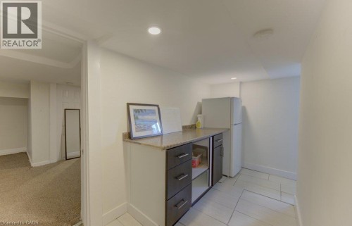 Built-in cabinetry with a stone-finish countertop, recessed lighting, and tile flooring - 10 Marshall Street, Waterloo, ON 