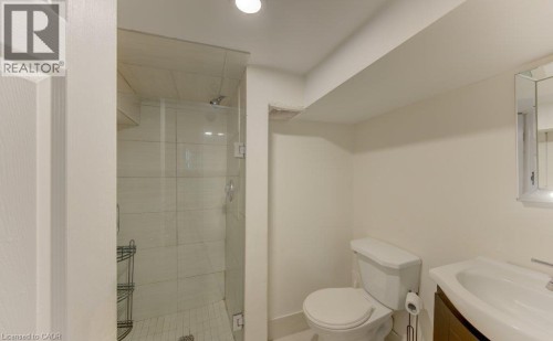 Glass-enclosed shower with tiled walls and a white subway tile floor - 10 Marshall Street, Waterloo, ON 