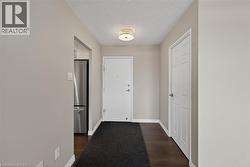 Entryway featuring dark wood-finish flooring, light grey wall tones, and white trim - 