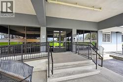 Building entrance featuring a multi-level concrete stairway and accessibility ramp - 