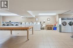 Spacious laundry facility featuring numerous front-loading washing machines and dryers - 