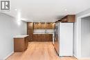 Kitchen featuring wood-finish flooring, recessed lighting, wood cabinetry, stone-look countertops, and a stainless steel refrigerator - 112 Nash Road S, Hamilton, ON  - Indoor Photo Showing Kitchen 