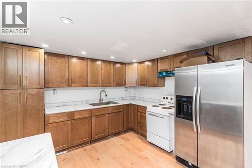 Kitchen featuring light wood-finish cabinetry, white countertops, stainless steel refrigerator, white range, and recessed lighting - 112 Nash Road S, Hamilton, ON - Indoor Photo Showing Kitchen