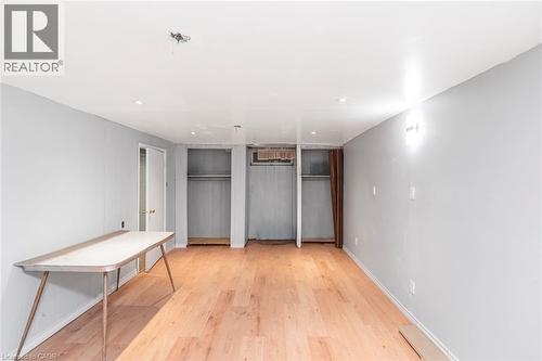 Spacious room featuring light wood-finish flooring, recessed lighting, and pale gray panel walls - 112 Nash Road S, Hamilton, ON - Indoor Photo Showing Other Room