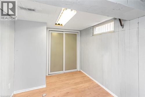 Room featuring wood-finish flooring, white paneled walls, and a fluorescent ceiling light - 112 Nash Road S, Hamilton, ON - Indoor Photo Showing Other Room