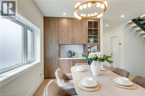 Dining area featuring extensive wood-finish cabinetry with an integrated display cabinet and a white countertop - 1411 Mountain Grove Avenue, Burlington, ON - Indoor Photo Showing Dining Room