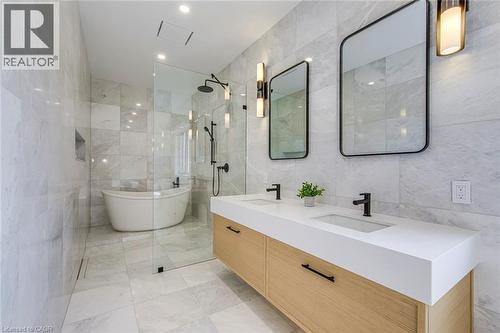 Contemporary bathroom featuring a freestanding tub, glass-enclosed shower with matte black fixtures, and a dual vanity with undermount sinks and wood-finish cabinetry - 1411 Mountain Grove Avenue, Burlington, ON - Indoor Photo Showing Bathroom