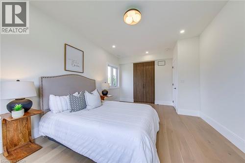 Light wood-finish flooring complements the white walls and recessed lighting - 1411 Mountain Grove Avenue, Burlington, ON - Indoor Photo Showing Bedroom