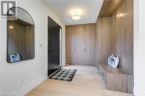 Entryway featuring custom wood-finish built-in cabinetry, wood-finish flooring, a built-in bench, and a modern ceiling light fixture - 1411 Mountain Grove Avenue, Burlington, ON - Indoor Photo Showing Other Room