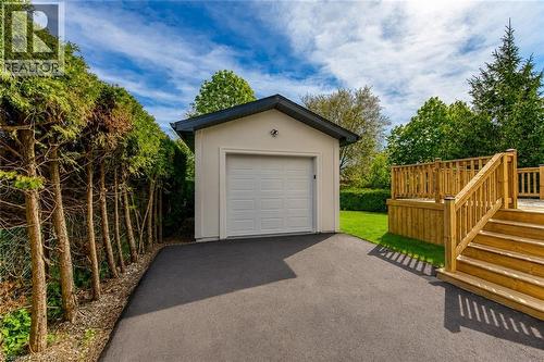 Detached garage with a paneled garage door, asphalt driveway, and a wood-stained deck with stairs and railings - 1411 Mountain Grove Avenue, Burlington, ON - Outdoor With Exterior