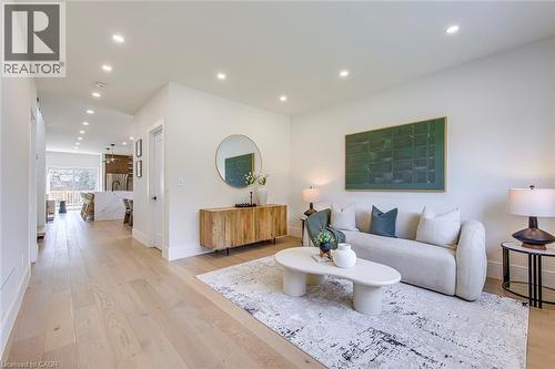 Open-concept living space featuring light wood-finish flooring, recessed lighting, white walls, and a visible kitchen beyond - 1411 Mountain Grove Avenue, Burlington, ON - Indoor Photo Showing Living Room