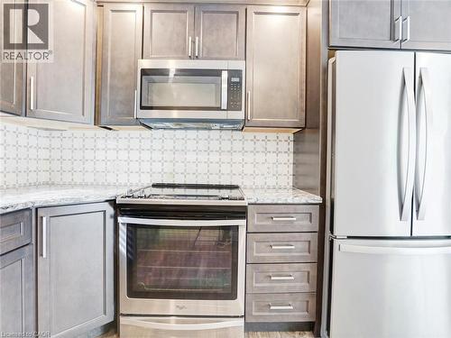 Contemporary kitchen featuring gray shaker-style cabinetry, granite countertops, and a decorative tile backsplash - 833 Doon Village Road, Kitchener, ON - Indoor Photo Showing Kitchen With Upgraded Kitchen