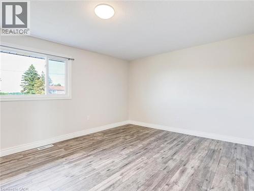 Spacious room featuring wood-finish flooring, white baseboards, and neutral wall tones - 833 Doon Village Road, Kitchener, ON - Indoor Photo Showing Other Room