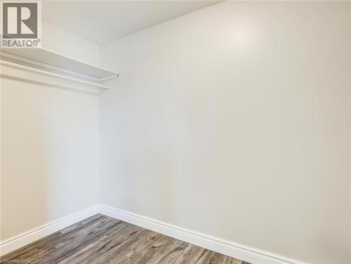 Storage closet featuring wood-finish flooring, white walls, and white baseboards - 833 Doon Village Road, Kitchener, ON - Indoor Photo Showing Other Room