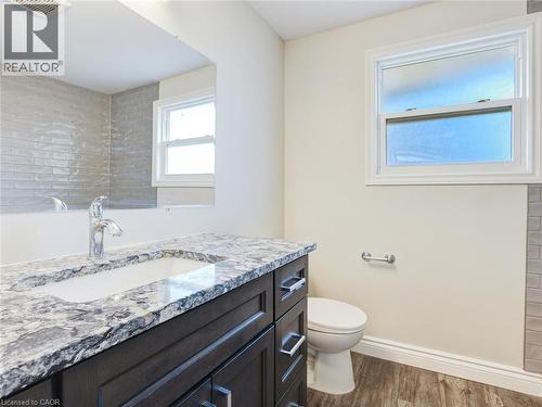 Bathroom vanity featuring a polished chrome faucet, under-mount sink, and granite countertop - 833 Doon Village Road, Kitchener, ON - Indoor Photo Showing Bathroom