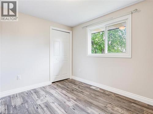 Light-filled room featuring wood-finish flooring, white baseboards, and a bi-fold closet door - 833 Doon Village Road, Kitchener, ON - Indoor Photo Showing Other Room