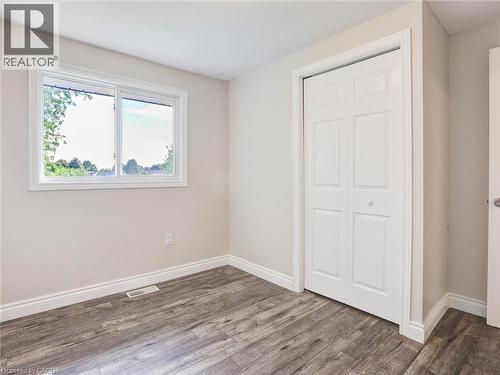 Light-filled room featuring wood-finish flooring, a white-framed window, and bi-fold closet doors - 833 Doon Village Road, Kitchener, ON - Indoor Photo Showing Other Room