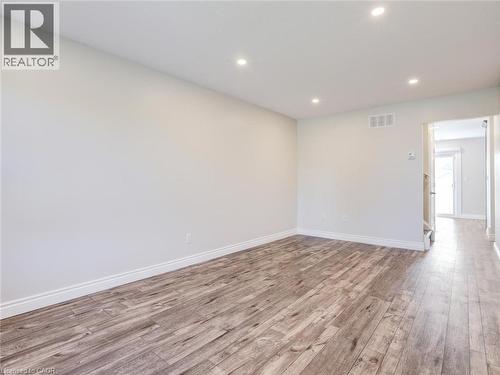 Spacious room with wood-finish flooring, recessed lighting, white baseboards, and neutral wall tones - 833 Doon Village Road, Kitchener, ON - Indoor Photo Showing Other Room