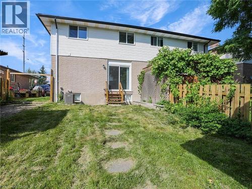 Rear exterior featuring a sliding glass door, a wooden staircase, and a brick and siding facade - 833 Doon Village Road, Kitchener, ON - Outdoor