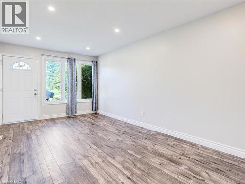 Spacious room featuring wood-finish flooring, recessed lighting, and expansive windows - 833 Doon Village Road, Kitchener, ON - Indoor Photo Showing Other Room