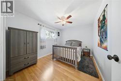 Bedroom featuring light wood-style flooring, ceiling fan, and a textured ceiling - 