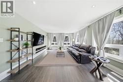 Living area with dark wood-type flooring and recessed lighting - 