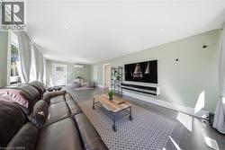 Living room with wood finished floors, healthy amount of natural light, and recessed lighting - 
