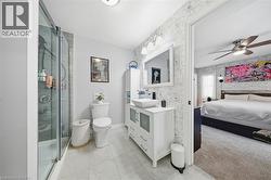 Ensuite bathroom featuring wallpapered walls, a ceiling fan, a shower stall, and vanity - 