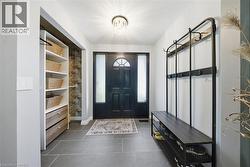 Mudroom featuring a chandelier and dark tile patterned floors - 