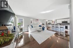 Living area featuring dark wood-style flooring and recessed lighting - 