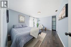 Bedroom with dark wood finished floors and baseboards - 
